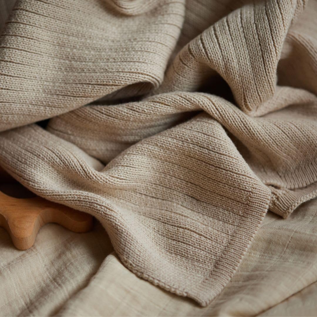 Huxie knitted baby blanket washing instruction shot emphasizes low-heat tumble-dry care.