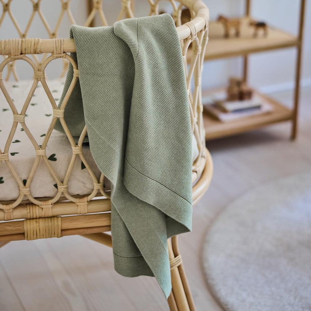 Huxie knitted organic baby blanket in car seat highlights safe comfort on long rides.