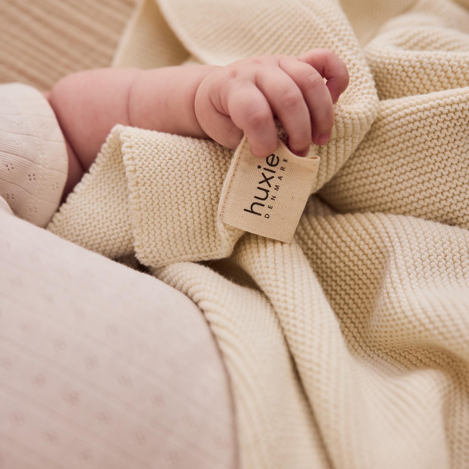 Huxie knitted organic baby blanket cuddling with toddler shows cozy versatility.