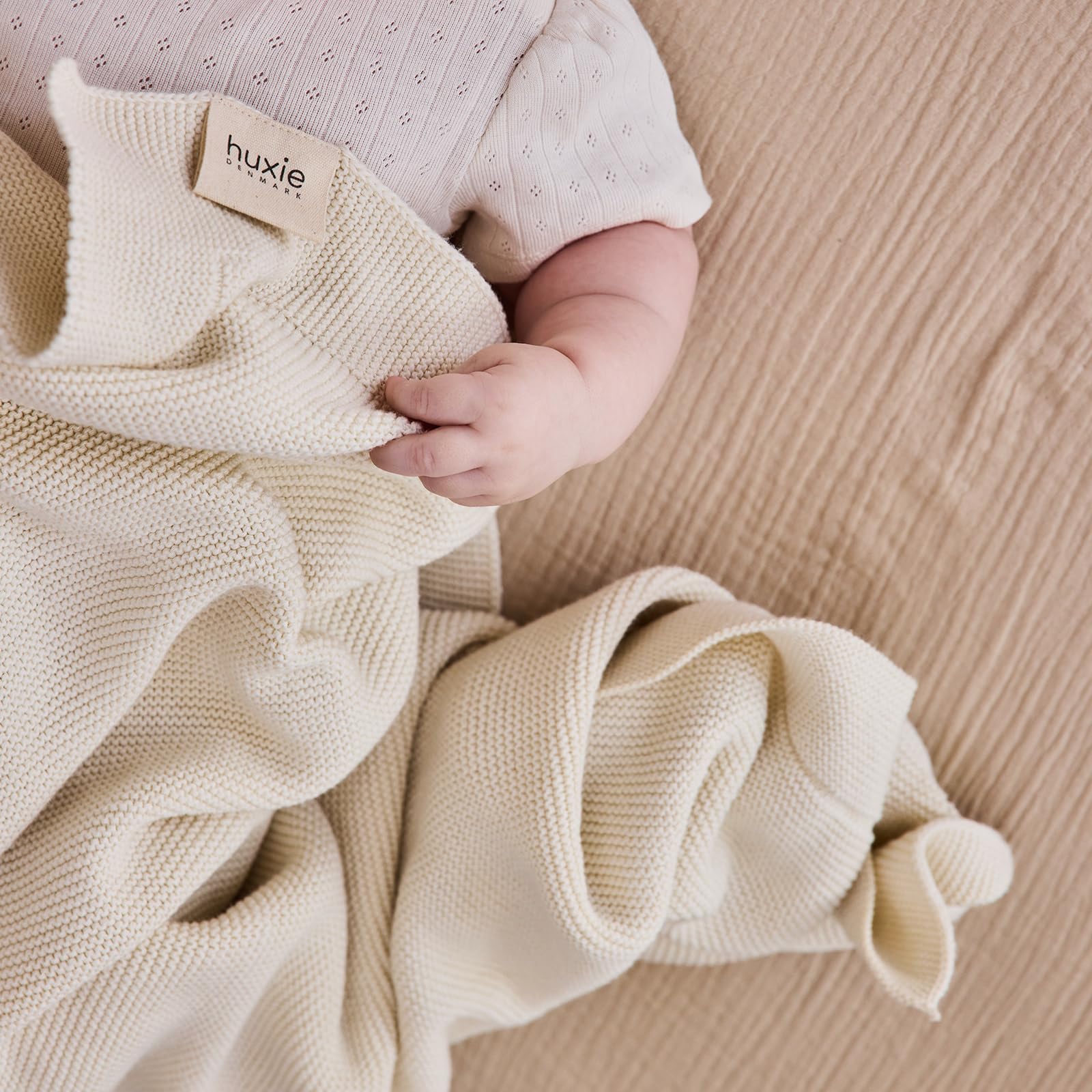 Huxie knitted organic baby blanket nursery-crib scene highlights breathable warmth.