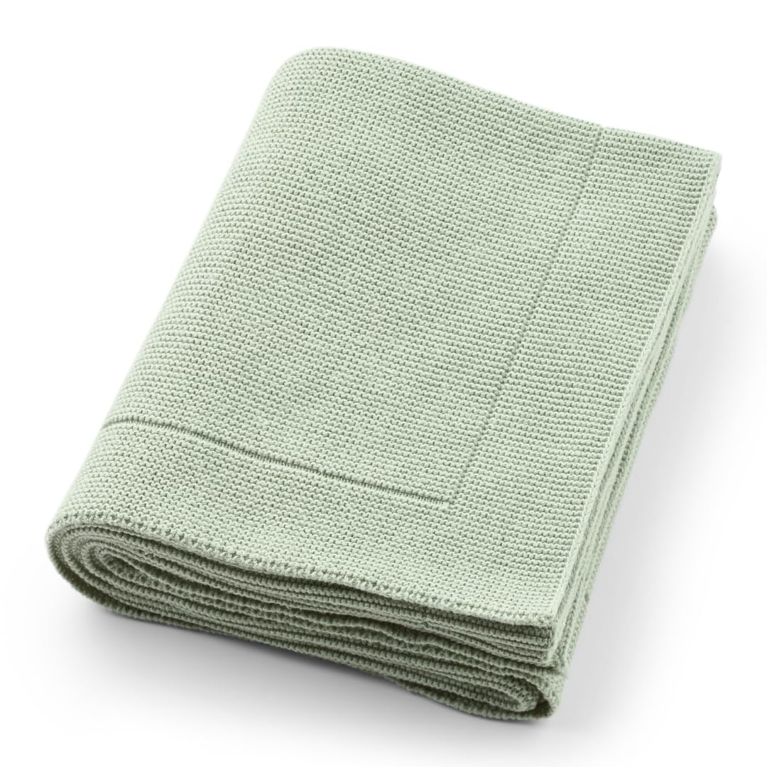 Huxie knitted organic baby blanket in Roman Green folded for warm, cozy nursery vibes.