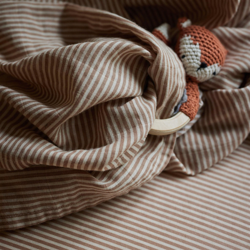 Huxie mini crib sheet cozy baby bed scene highlights comfort and a calm sleep environment.