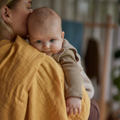 Huxie Swaddle natural closeup—breathable muslin keeps baby snug and warm