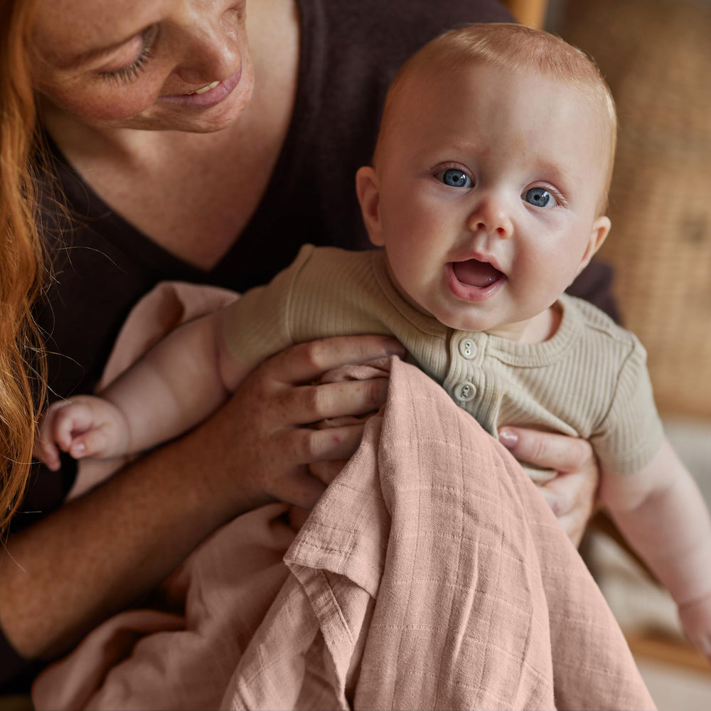 Huxie Swaddle receiving blanket depicts cozy cuddle and lightweight warmth.