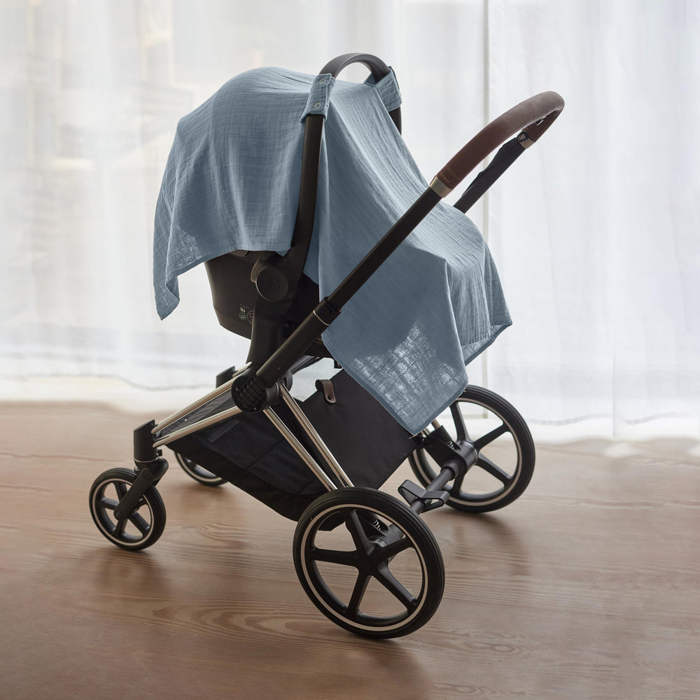 Huxie Tradewinds muslin blanket used as a swaddle for calm moments.