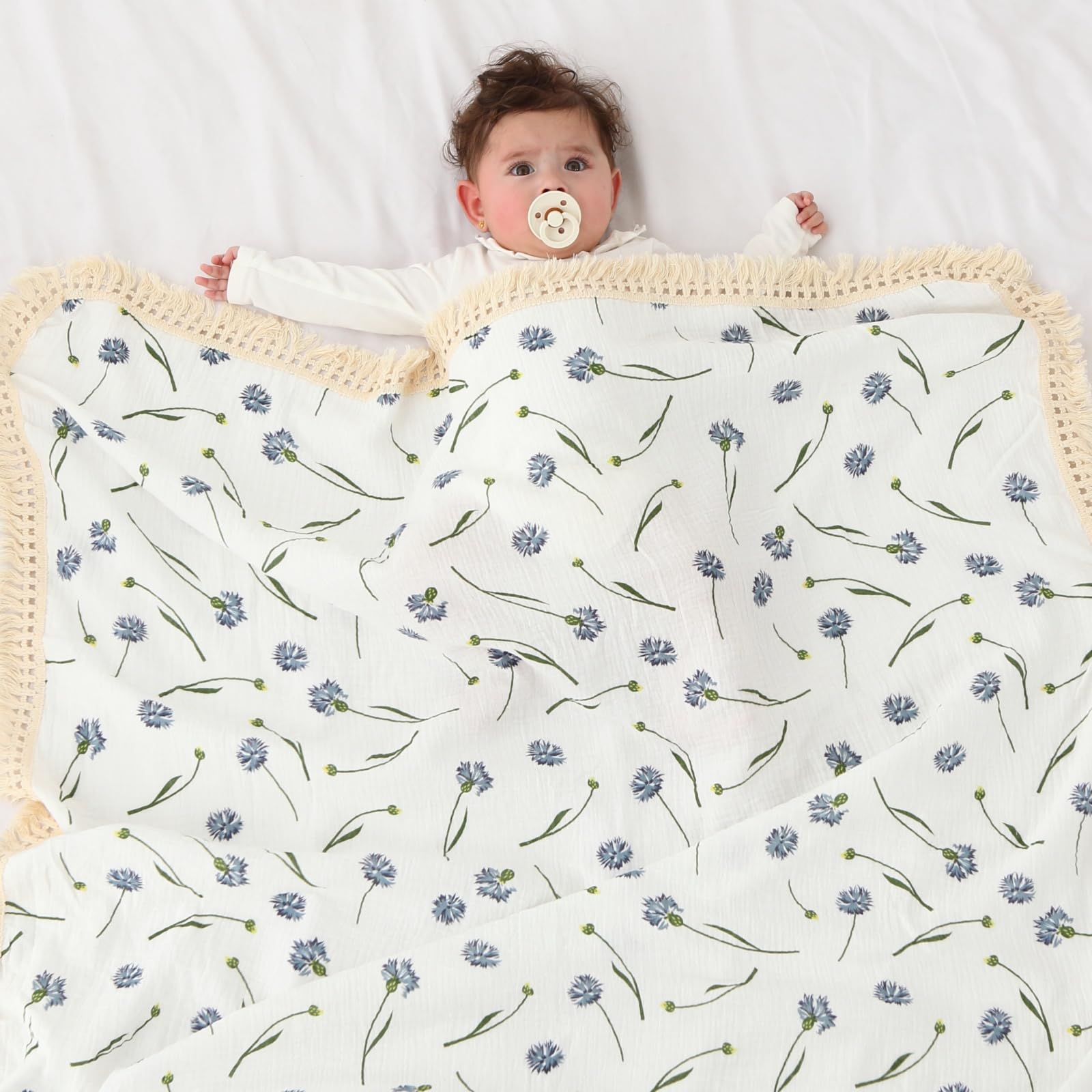 Insular cotton muslin baby blanket blue dandelion tassels closeup highlights four-sided boho fringe for cozy decor.