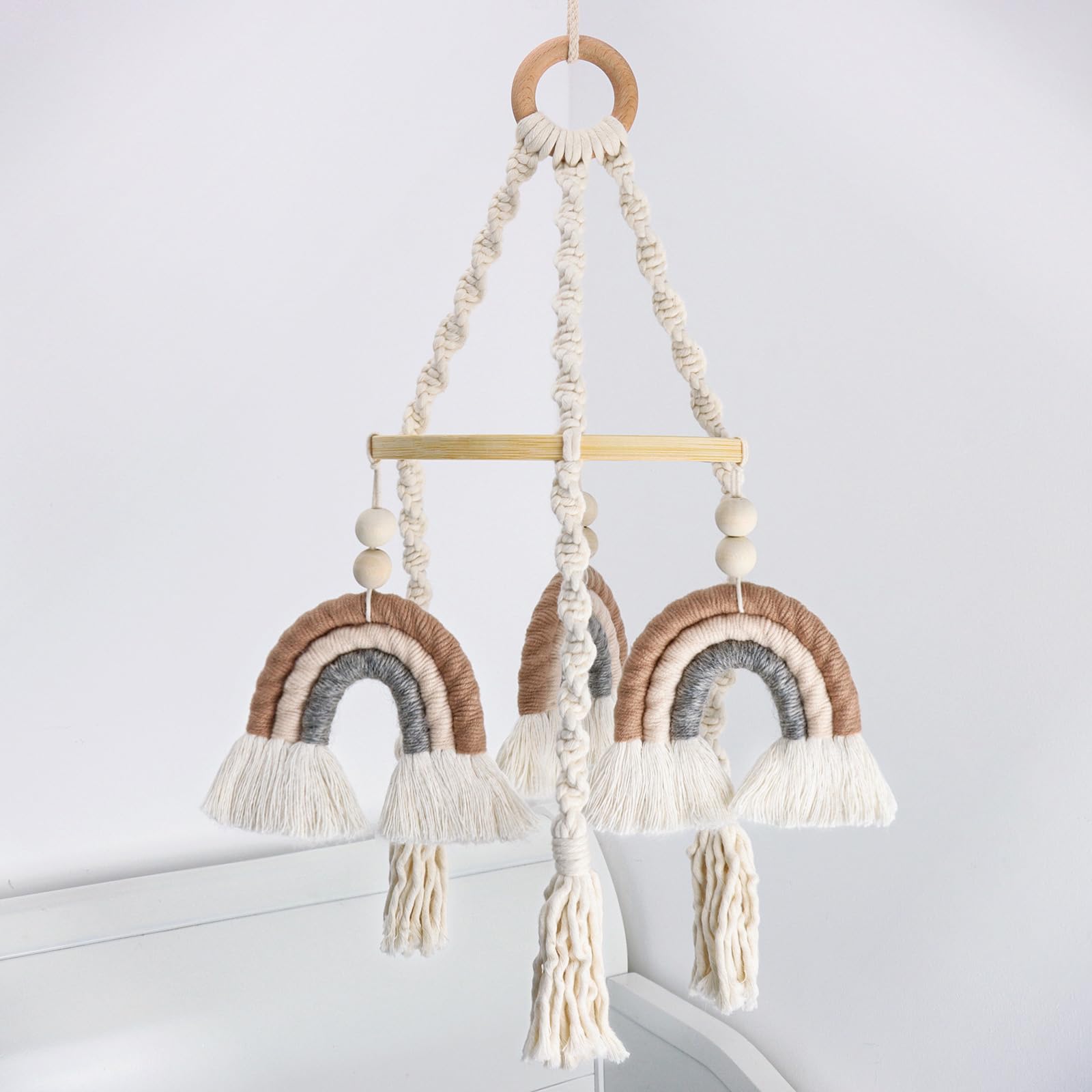 JILPAK neutral baby crib mobile with macrame rainbow shines softly over a crib, inspiring calm visual focus.