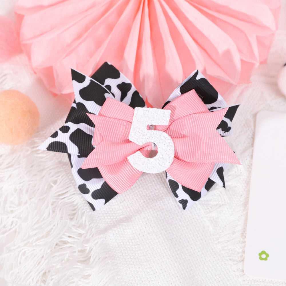 Jissoo cow print bow headband at farm-themed party, versatile decor and accessory.