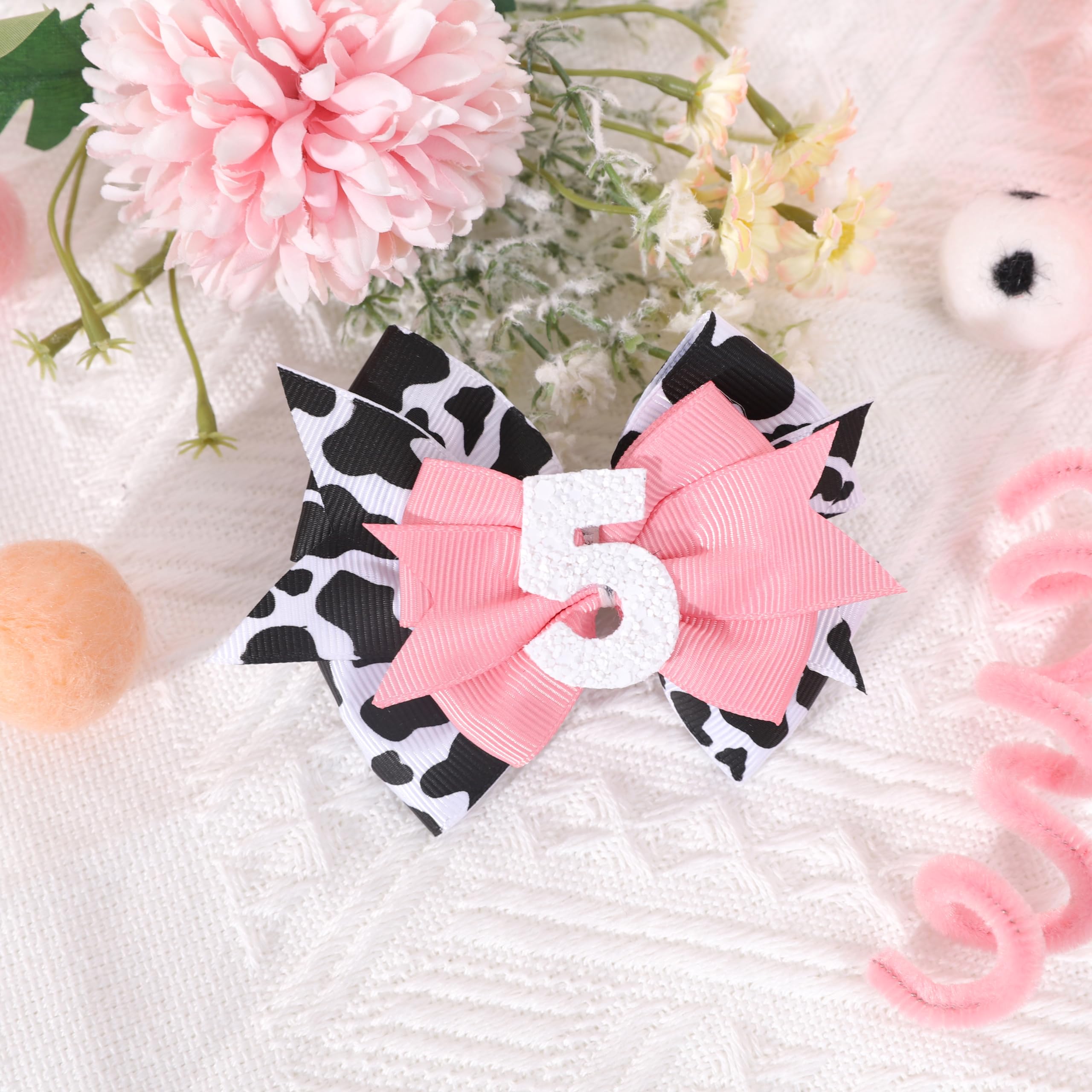 Jissoo cow print bow headband during photoshoot, enhances memorable birthday portraits.