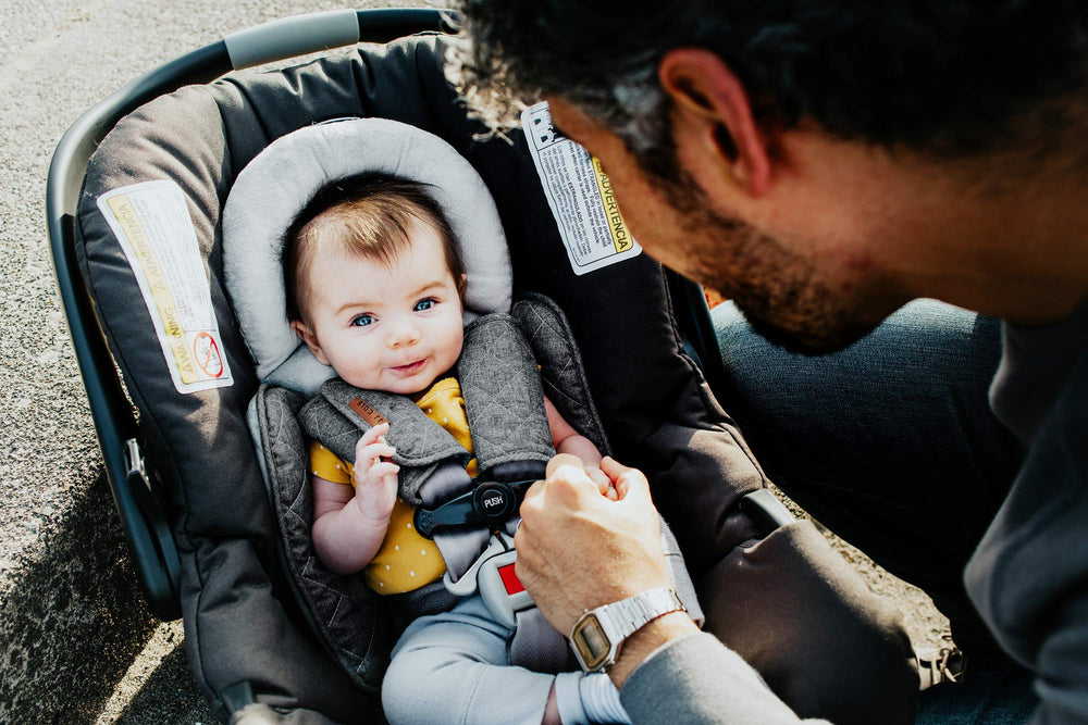 JJ Cole seat belt cover attachment demonstrates easy hook-and-loop wrap around car straps.