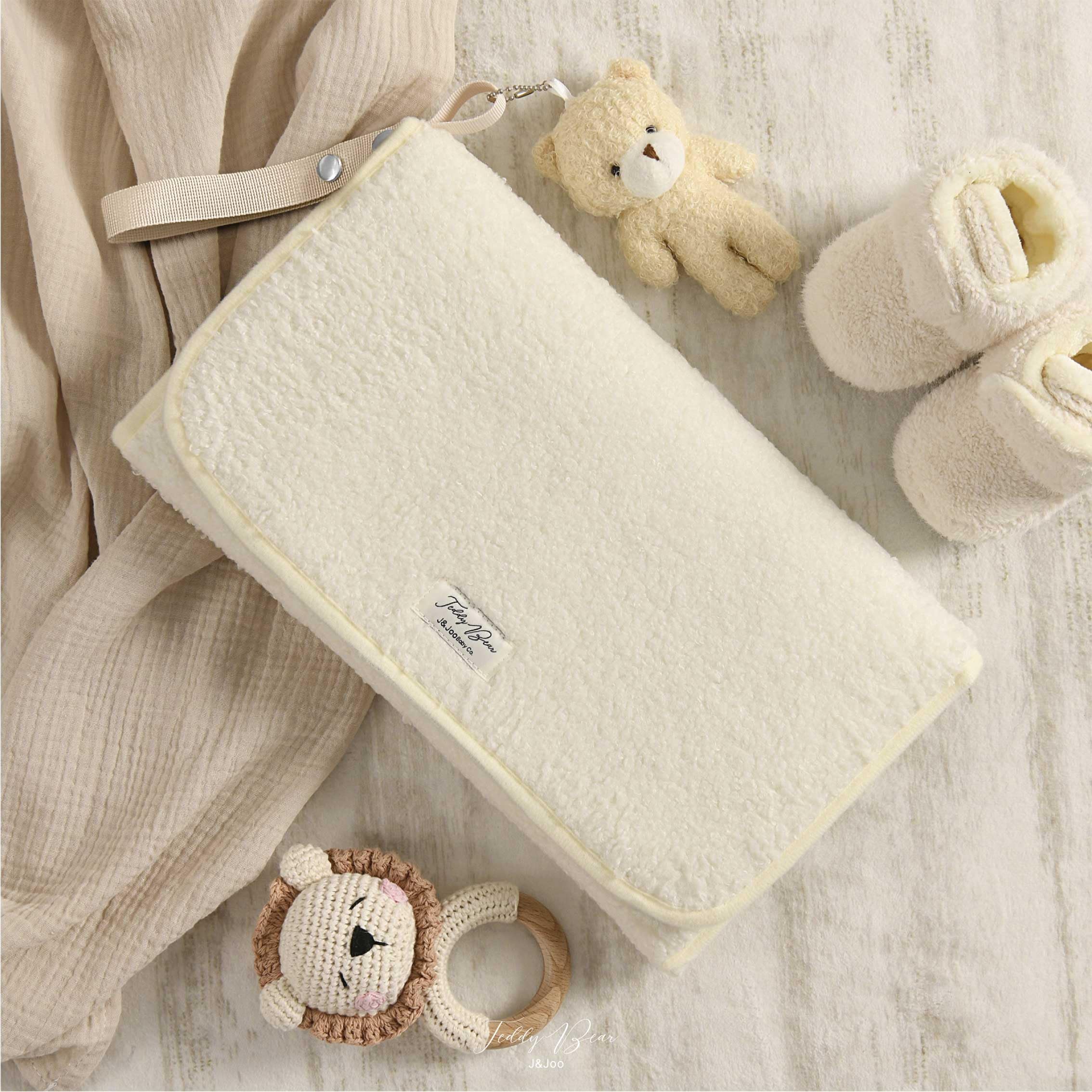 JJOO travel changing pad with mesh pockets for quick access to wipes and diapers.
