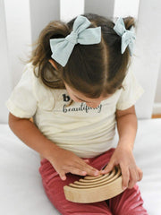JoCoDesigns clips clip on either side for versatile styling like braids or ponytails.