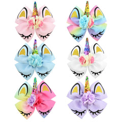 Close-up of Jollybows unicorn bows with clips on a pigtail for secure wear.