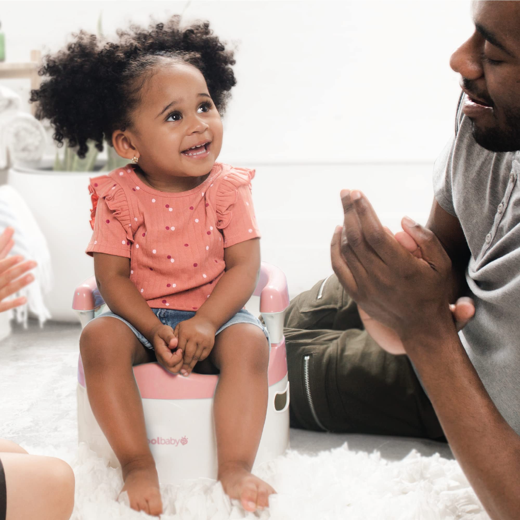 Jool Baby Potty Chair pink in-use demonstrates lightweight portability for home use.