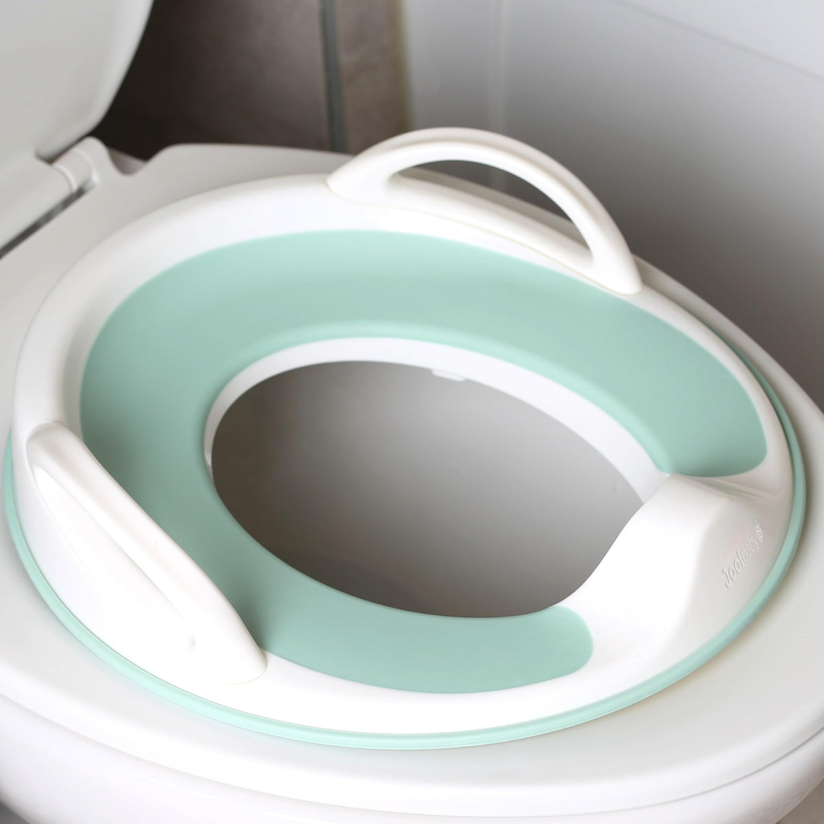 Jool Baby potty seat handles provide a secure grip for toddlers.