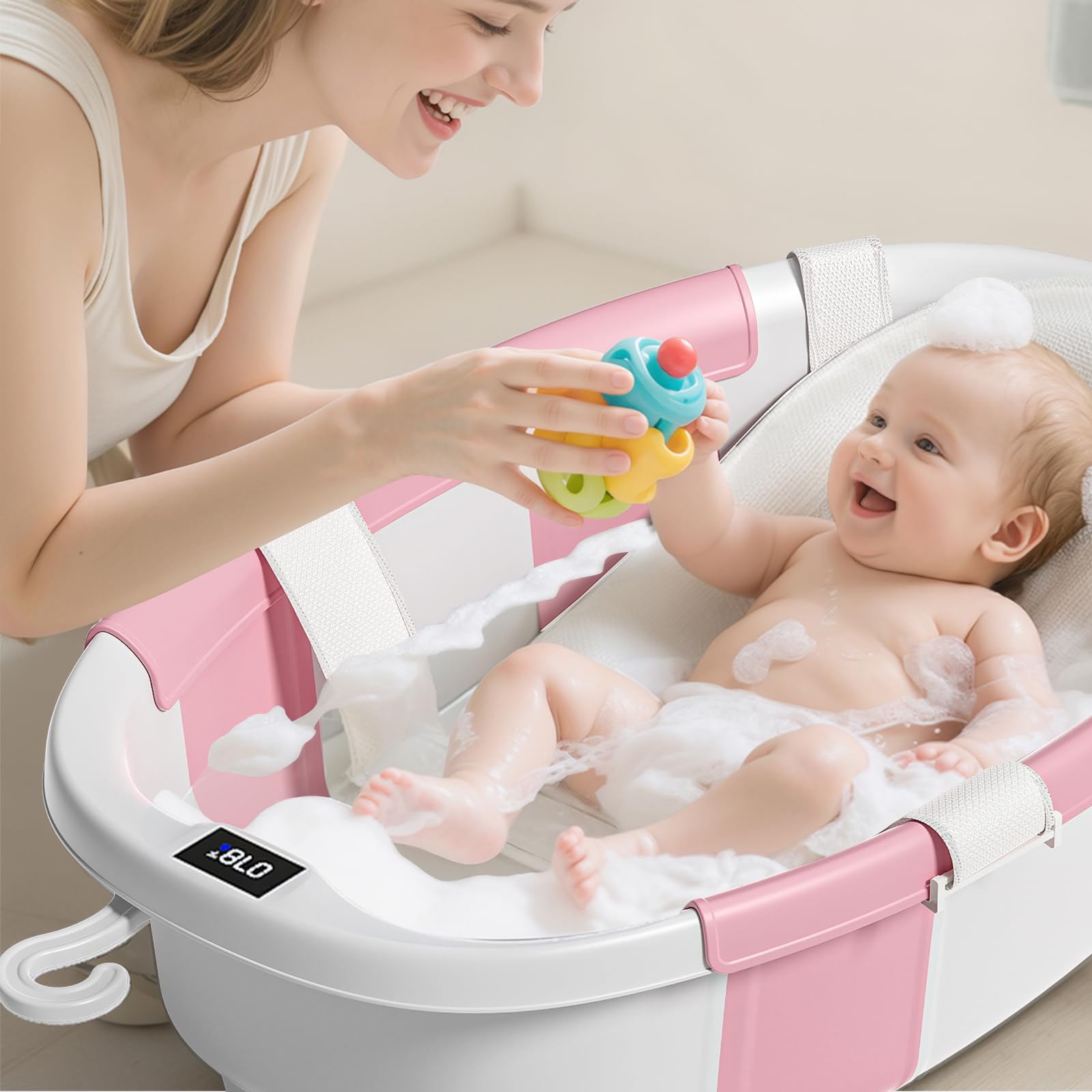 JoyYum collapsible baby bathtub in pink open and ready for use with cushion.