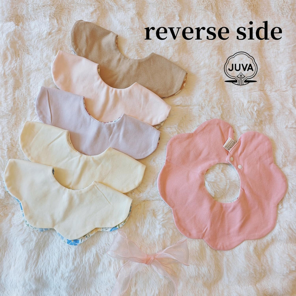 JUVA two-sided flower bib displaying reversible patterns for outfit coordination