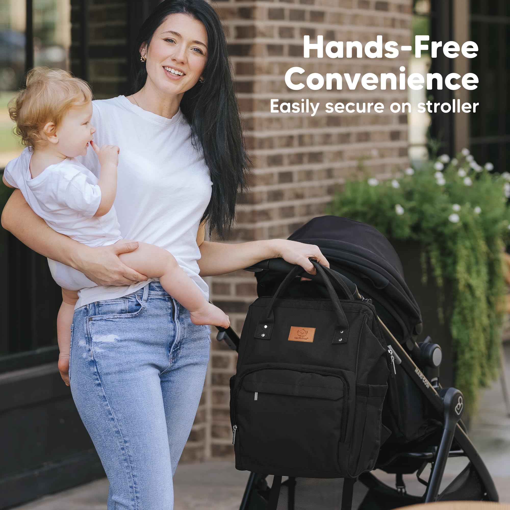 KeaBabies diaper bag backpack demonstrates hands-free use while carrying a baby.
