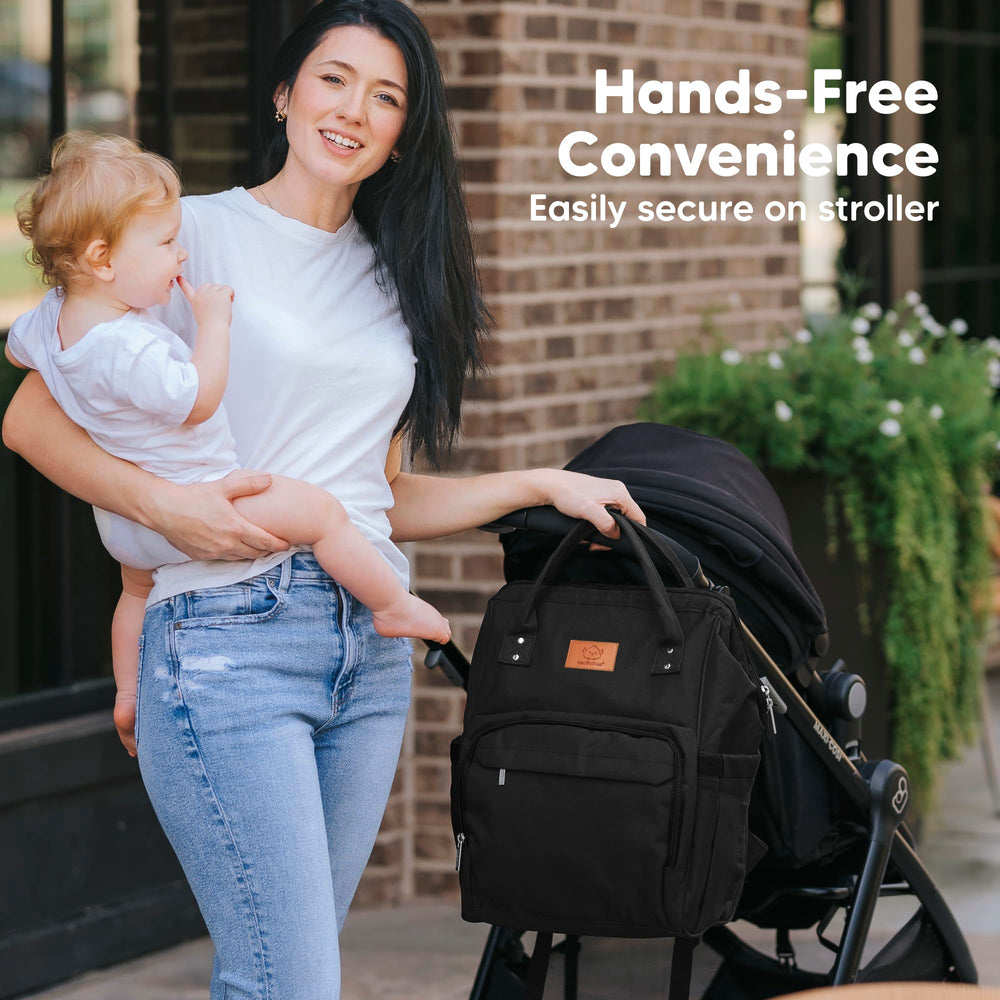 KeaBabies diaper bag backpack demonstrates hands-free use while carrying a baby.