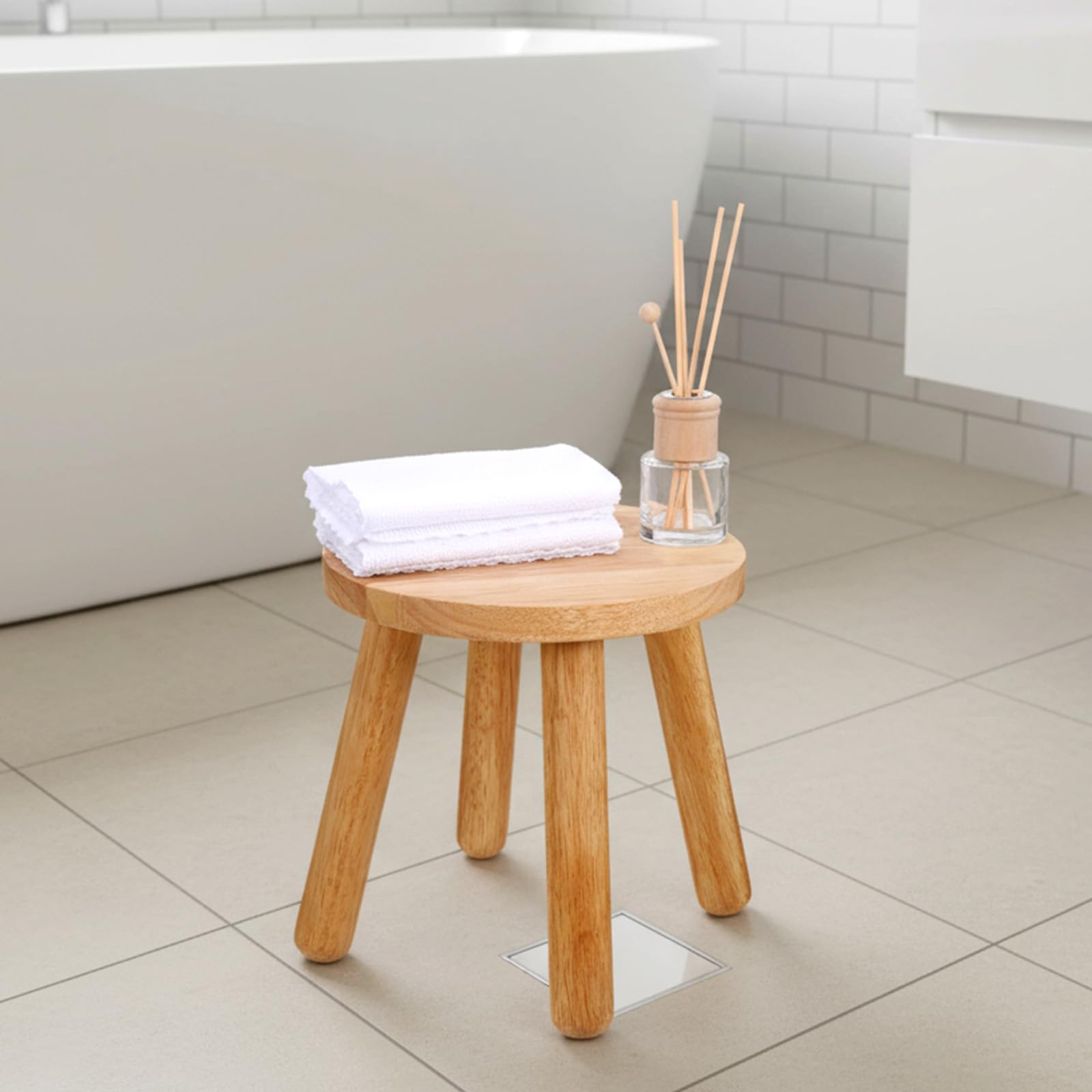 Kifmurase wooden round stool beside sofa as versatile compact seating.
