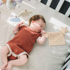 Knirose newborn security blanket in hands, portable calming companion for on-the-go soothing.