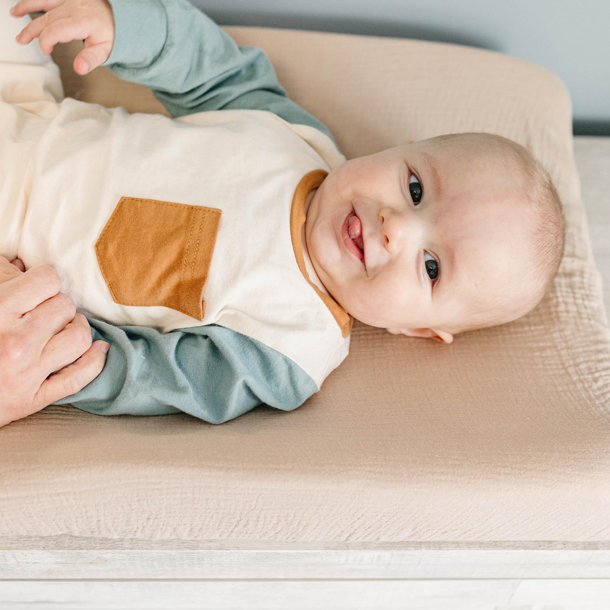 Konssy changing pad cover elasticized edge image emphasizes secure fit and slip prevention.