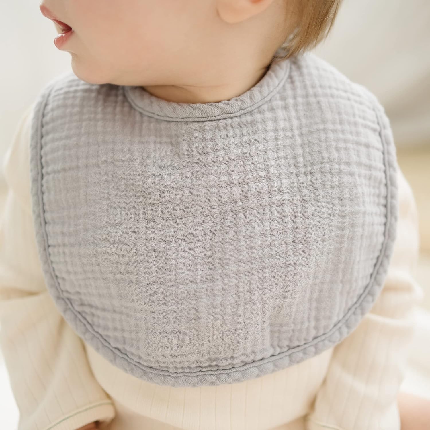 Konssy Muslin Bib worn by baby during teething for drool management.