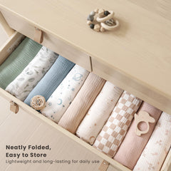 Konssy muslin swaddle being wrapped around newborn for secure sleep