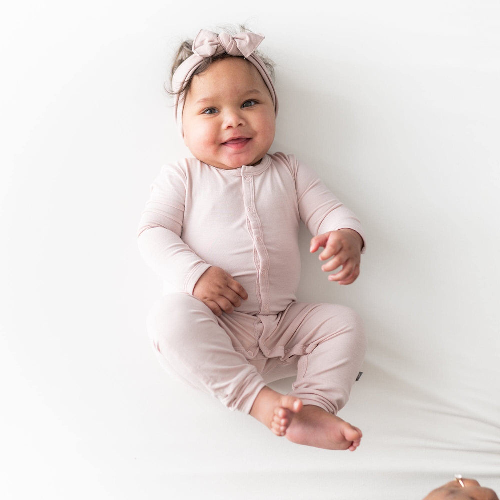 KYTE BABY bow on baby head, adjustable fit for comfy wear.