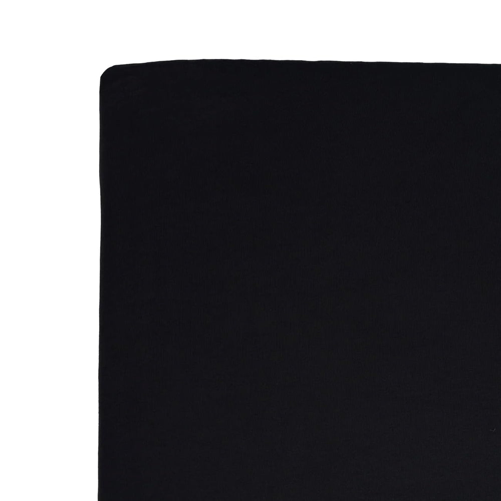 Kyte Baby crib sheet Midnight at bedside suggests easy night-time changes.