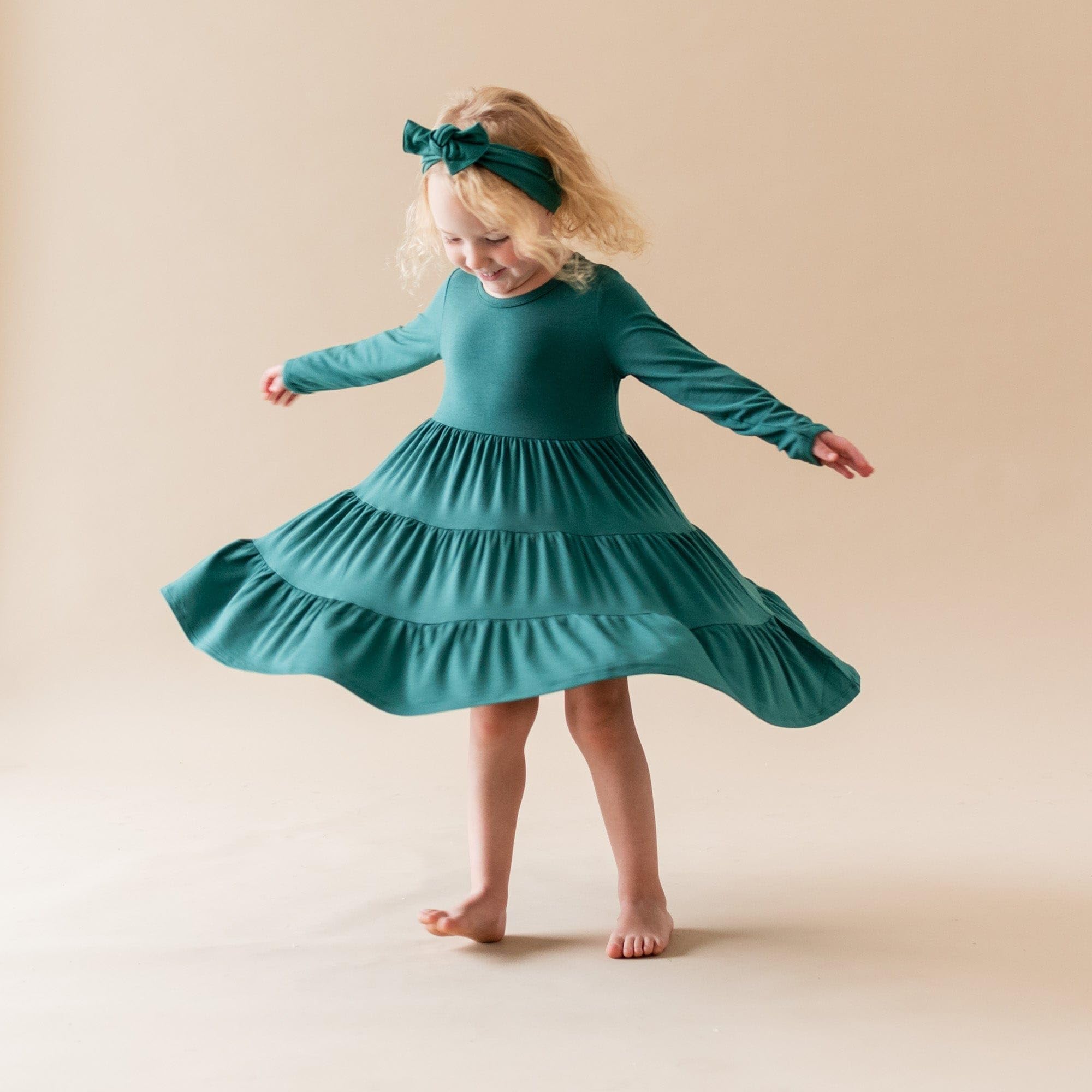 KYTE BABY bamboo bow emerald on baby demonstrates secure, non-tight fit for all-day wear.