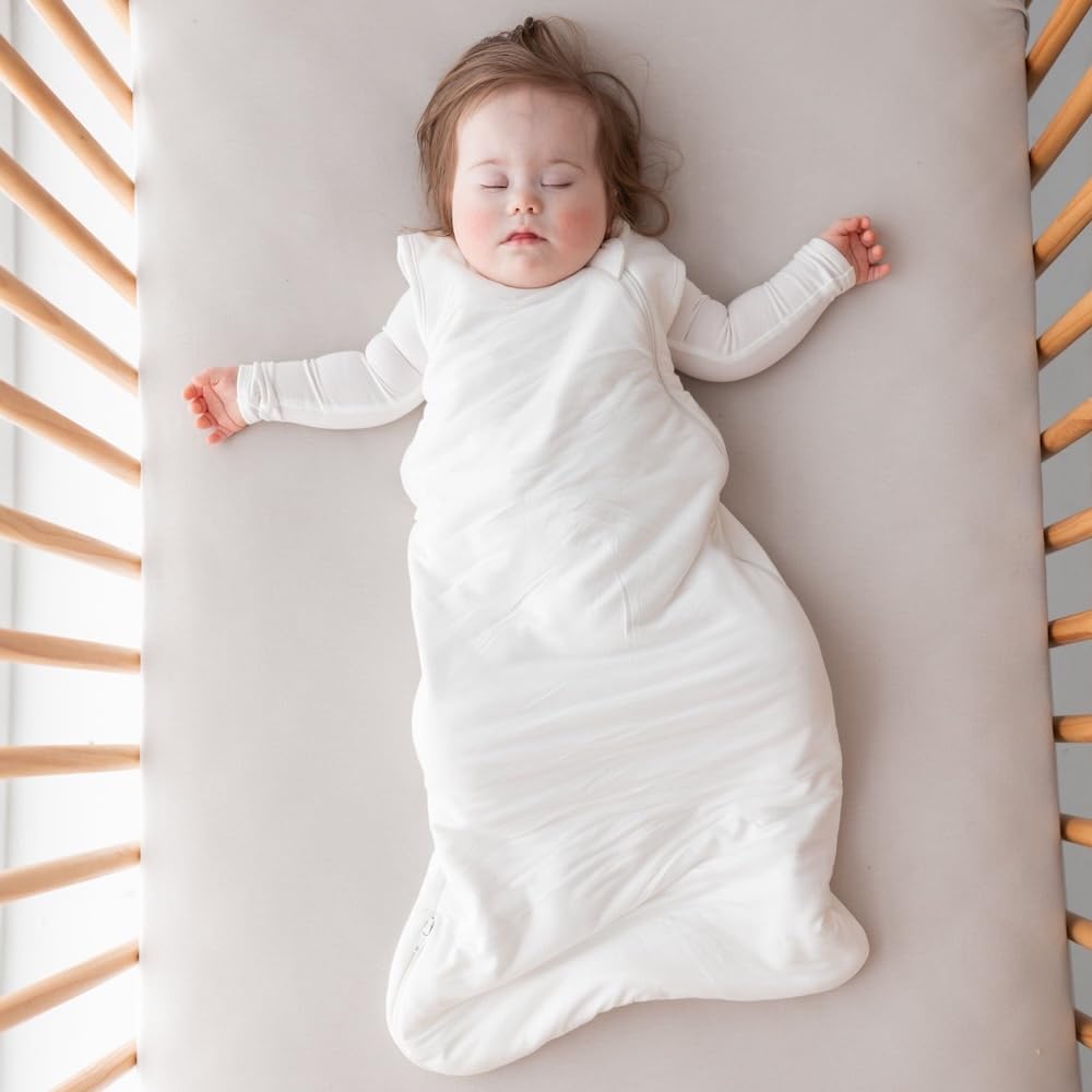 Kyte Baby soft crib sheet oat stretched-fit on mattress demonstrates snug, secure coverage
