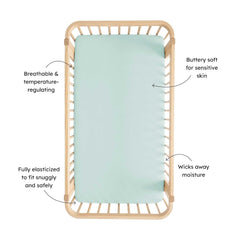 Kyte Baby sage crib sheet on mattress shows snug fit for secure sleep