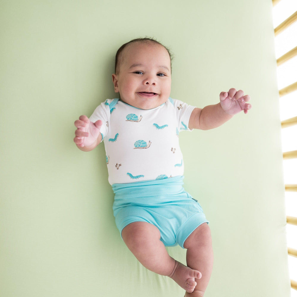 Kyte Baby pistachio crib sheet stretch-fit on mattress illustrating secure tuck