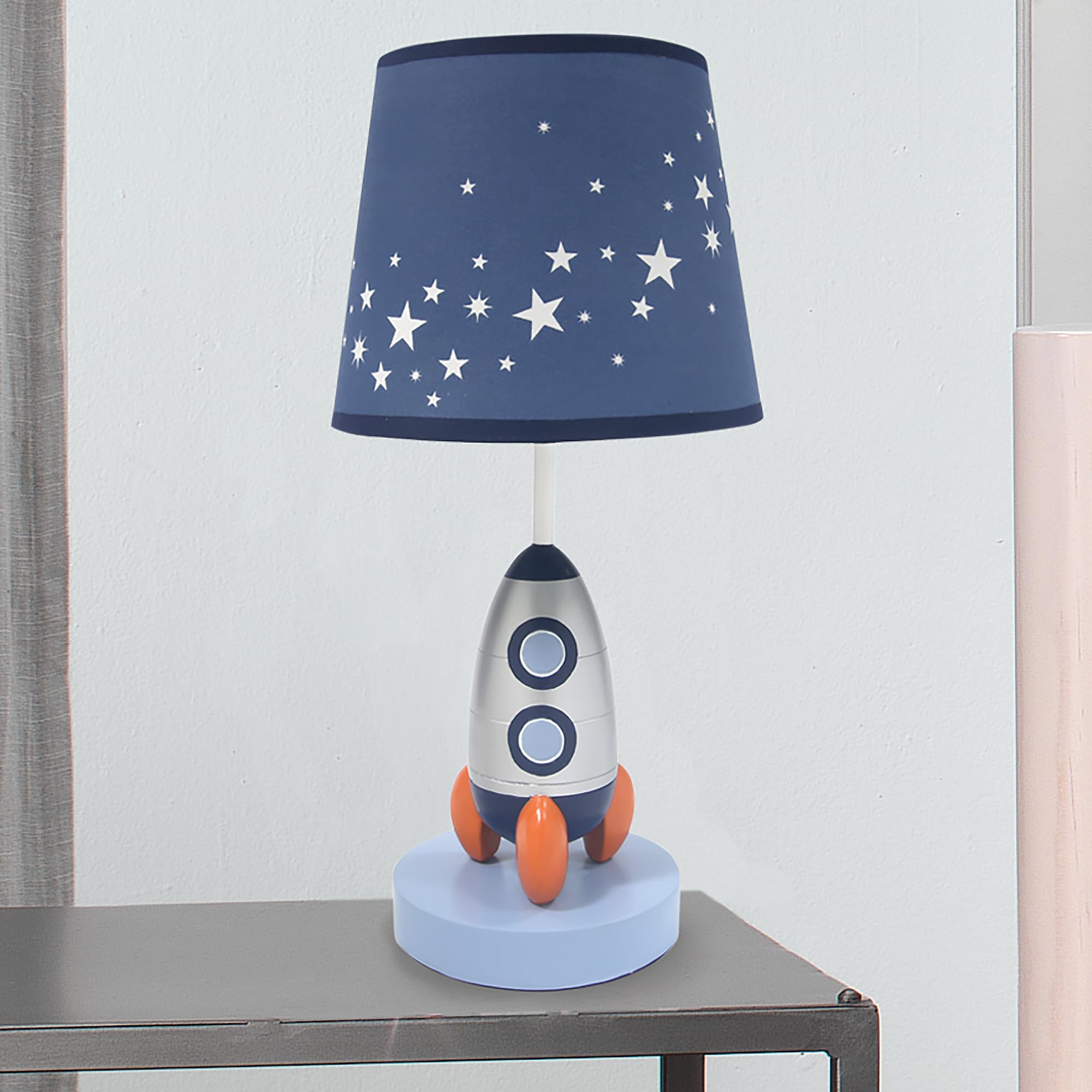 Lambs & Ivy Milky Way rocket lamp bulb included for quick setup.