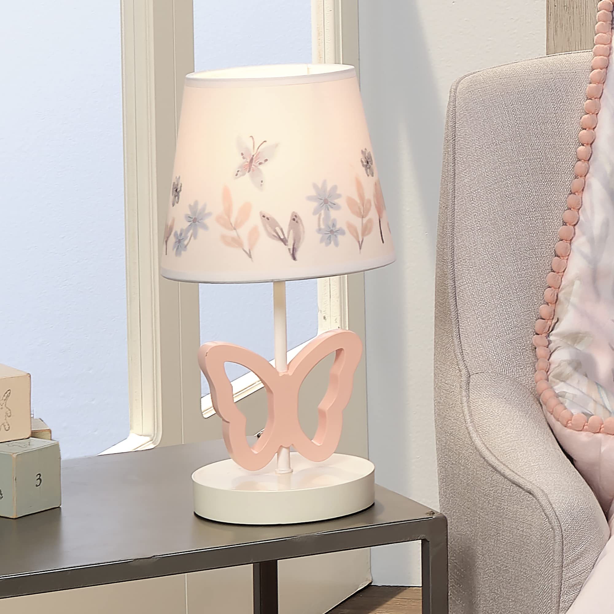 Lambs & Ivy Baby Blooms pink butterfly full lamp on a dresser for bedtime routines.