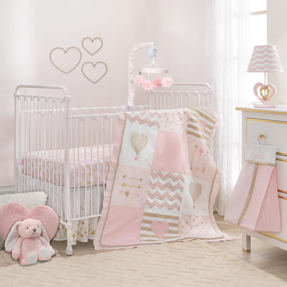 Lambs & Ivy Baby Love pink-gold comforter enhances cozy crib time.