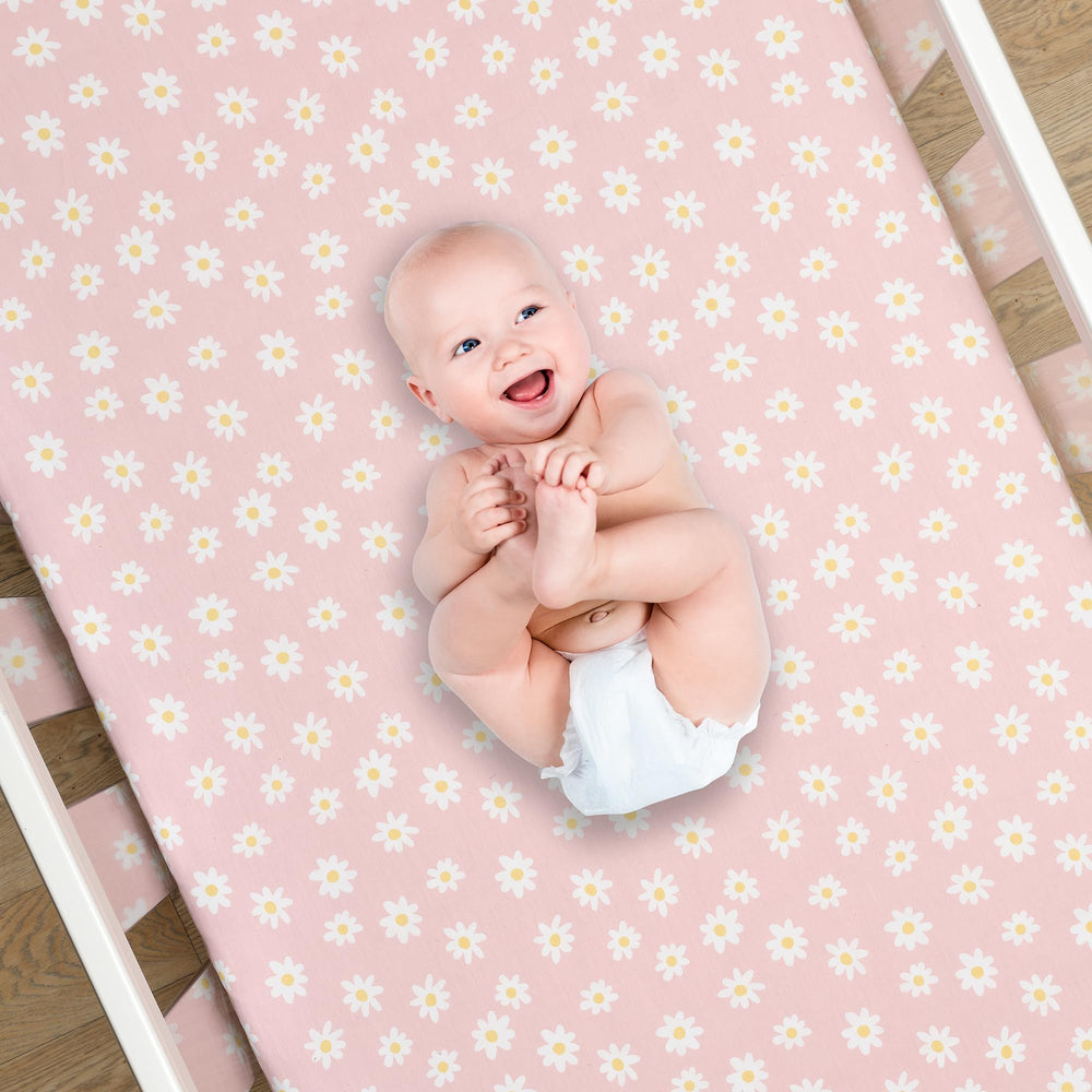 Lambs & Ivy Daisy Dreams fitted sheet on crib with secure elastic edge.
