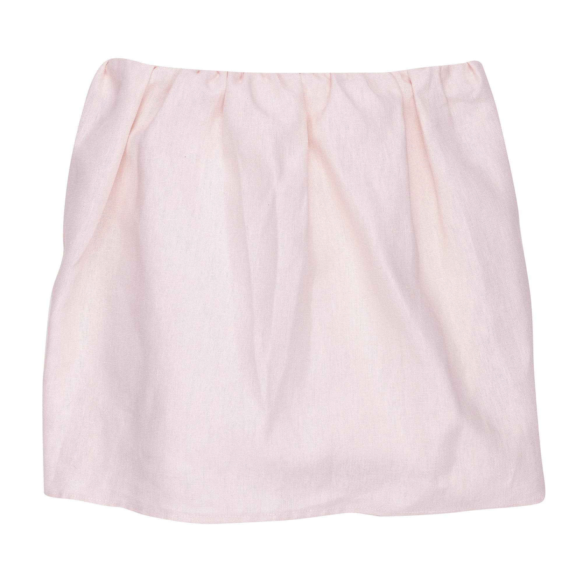 Lambs & Ivy Floral Garden pink linen crib skirt around crib posts for tidy framing.
