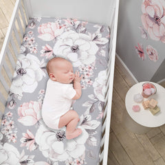 Lambs & Ivy Signature Botanical crib sheet shown on mattress with floral print.