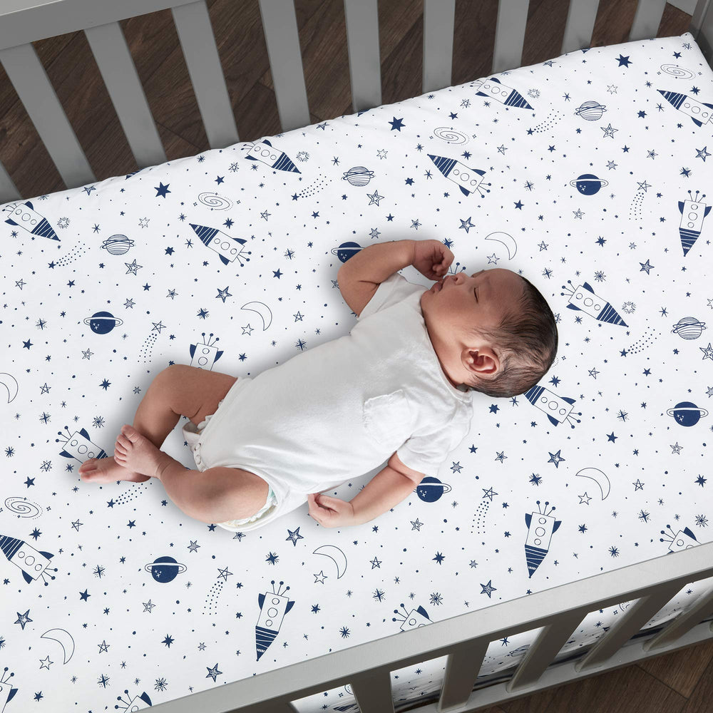 Lambs & Ivy Sky Rocket wall decals create a mural-like galaxy backdrop.