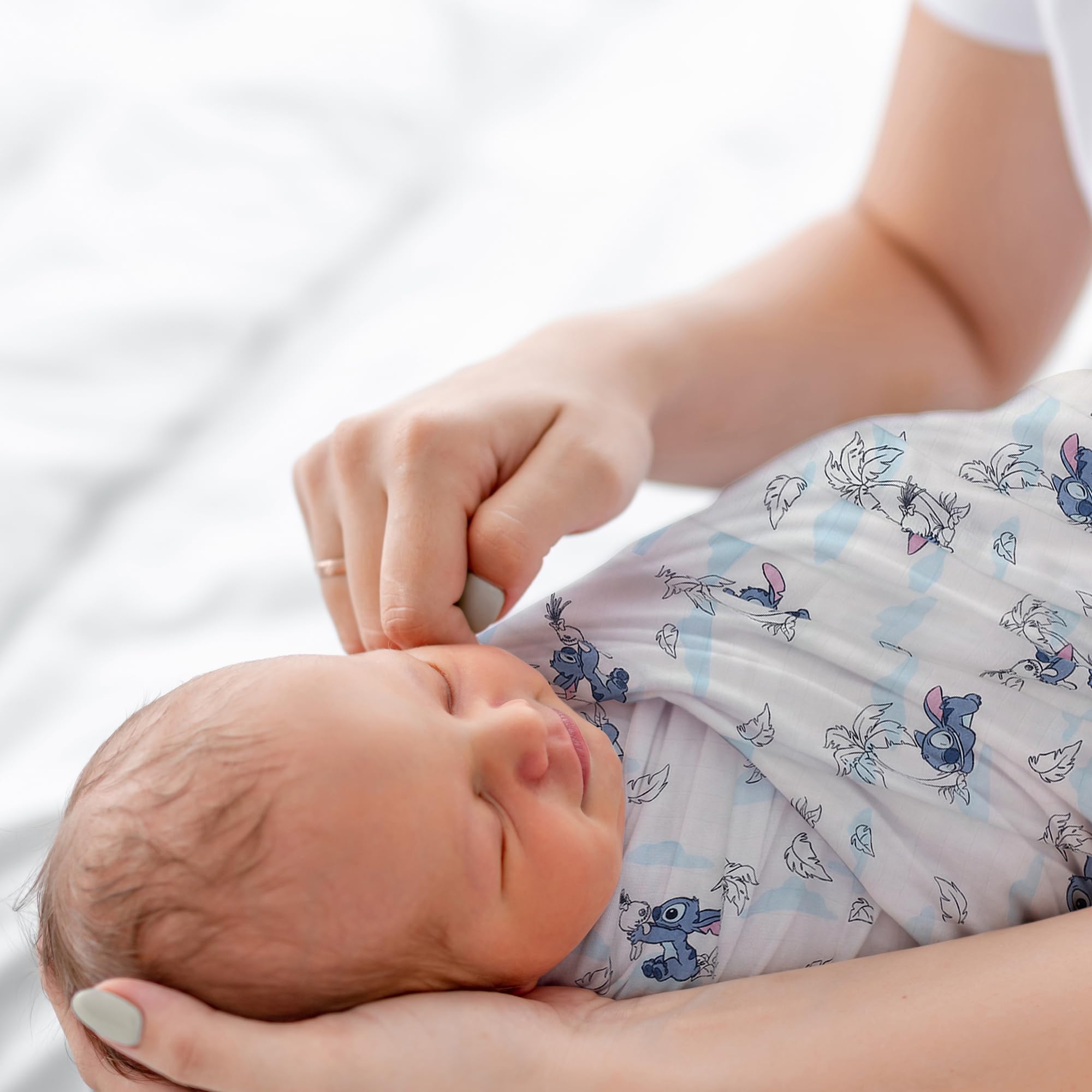 Lambs & Ivy white-ground swaddle—classic backdrop highlighting Stitch's favorite pose.