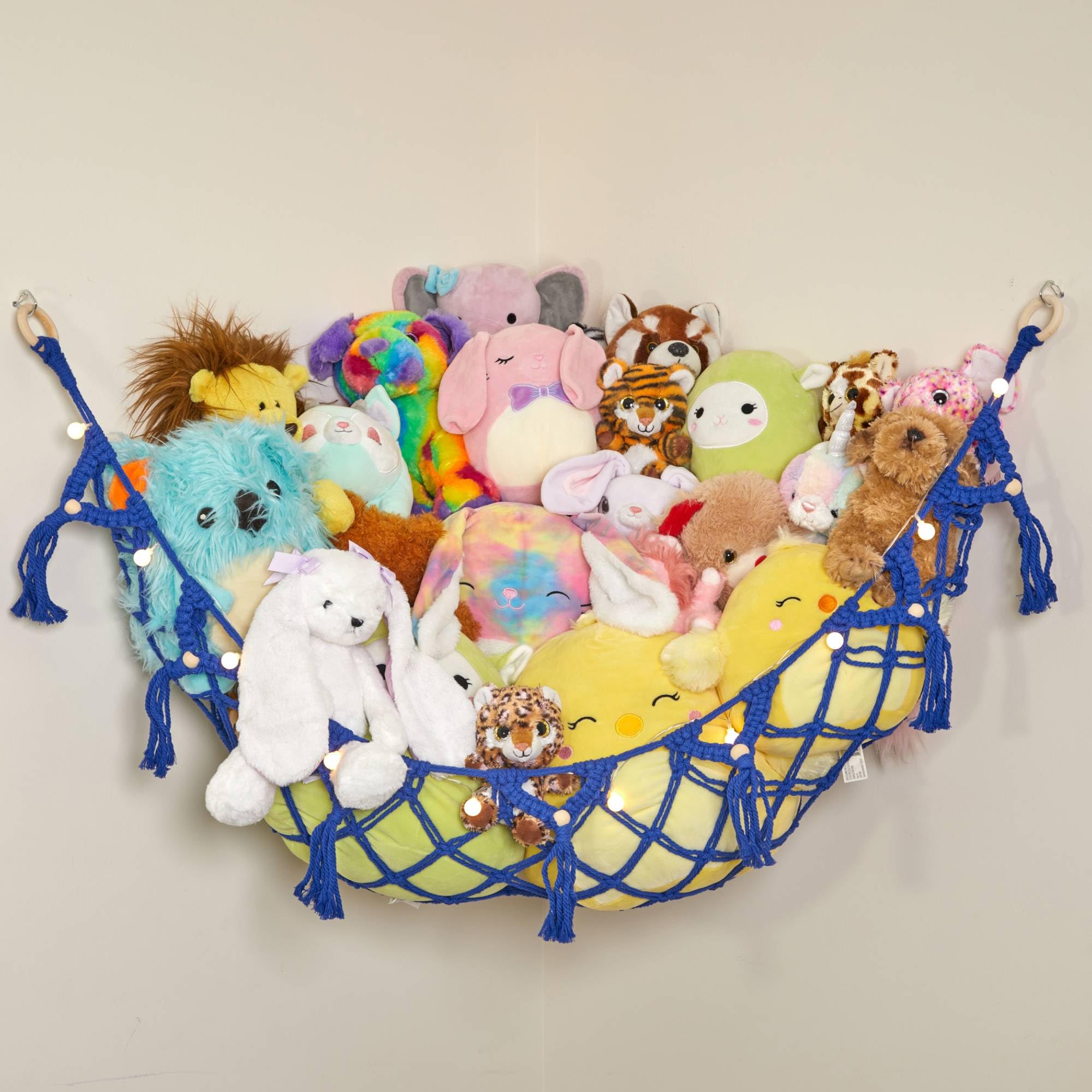 Lilly's Love dark blue macrame hammock storing plush toys in a corner