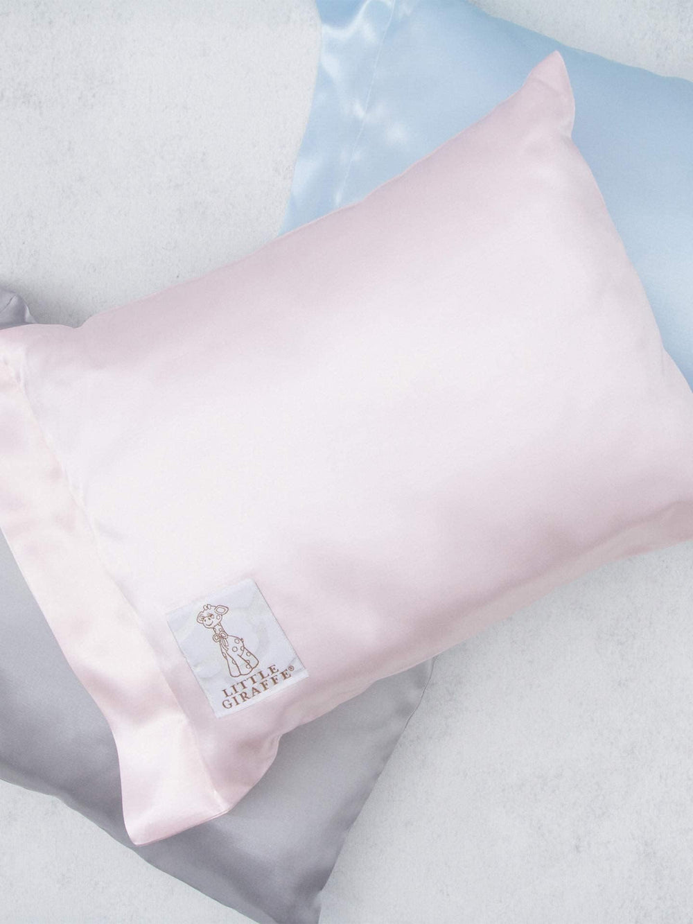 Little Giraffe Satin Decor Pillow 10x13 on bed shows compact, cozy support.