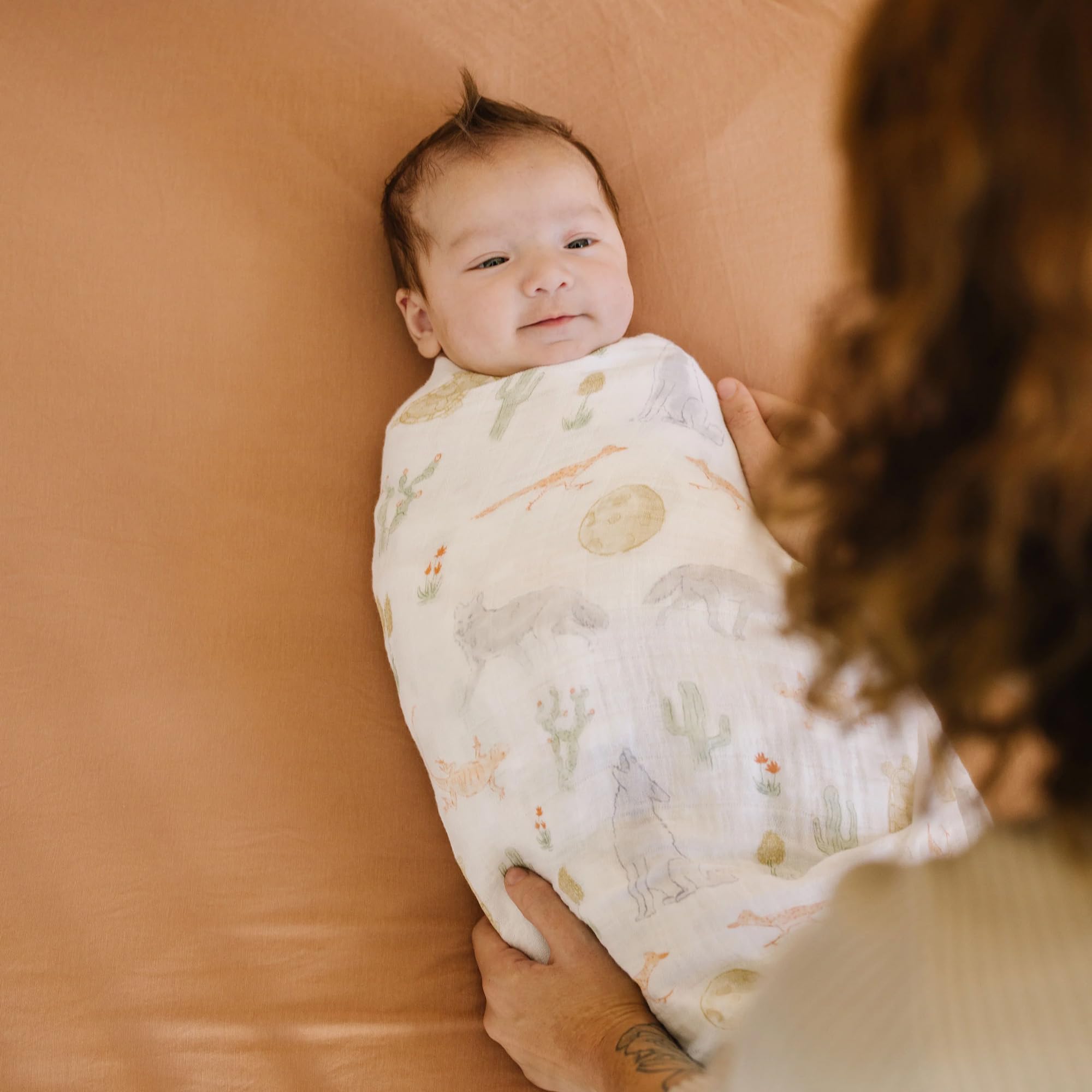 Little Unicorn Desert Night swaddle wrapped around a car seat for quick shade.