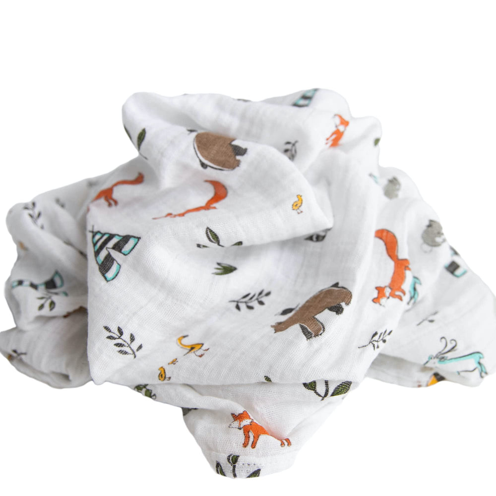 Little Unicorn Forest Friends swaddle on floor during playtime for comfort