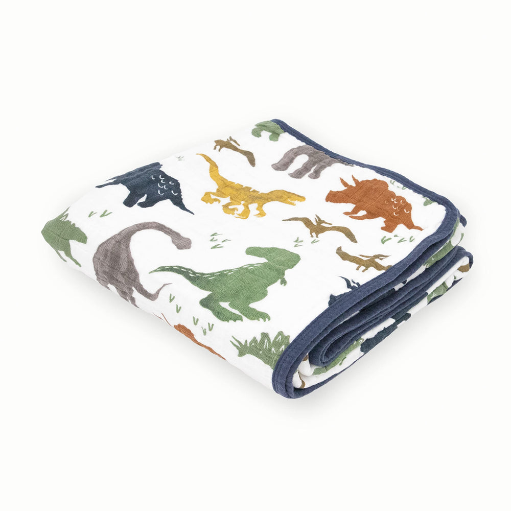 Little Unicorn Dino Friends quilt shown in a cozy nursery setup offering warm, gentle comfort