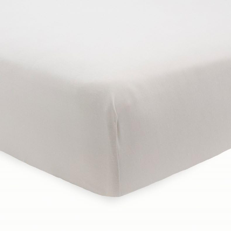 Little Unicorn Pebble stretch knit crib sheet on mattress highlighting soft viscose texture.