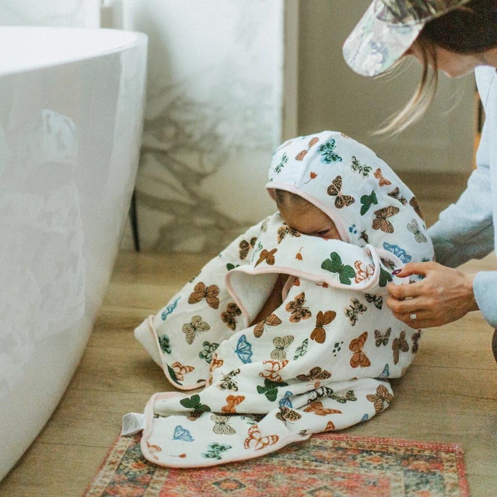 Little Unicorn premium hooded towel child using towel after bath—fun butterflies design.