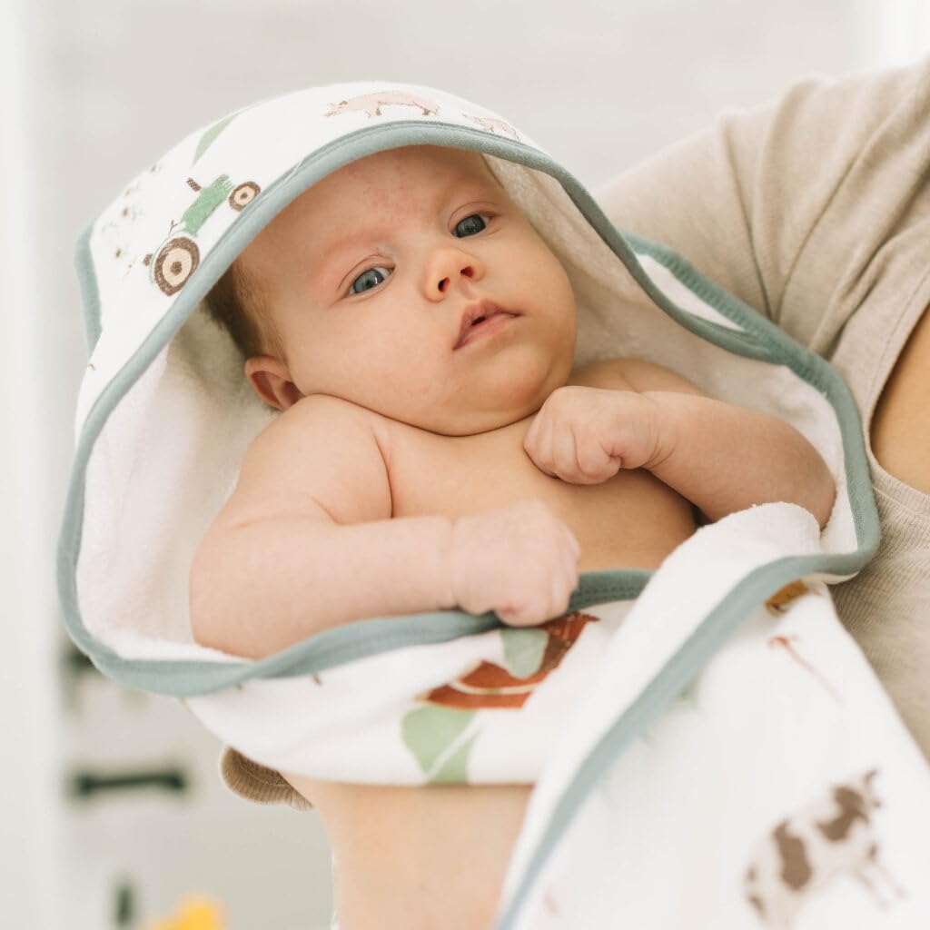Little Unicorn hooded towel in nursery setting emphasizes quick drying and snug wrap.